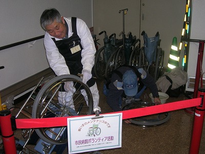 車椅子を整備するボランティアの画像