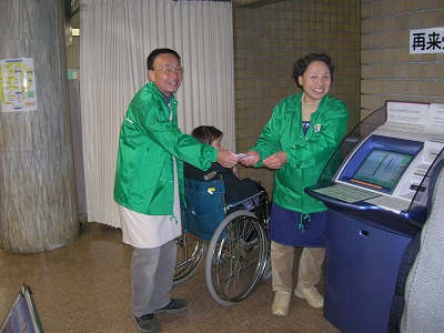 車椅子をお世話するボランティアの画像